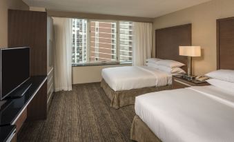 a hotel room with two beds , white linens , and large windows offering views of the city at Embassy Suites by Hilton Chicago Downtown Magnificent Mile
