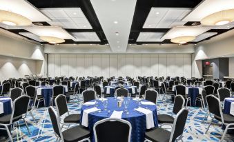 a large banquet hall with round tables and chairs set up for a formal event , possibly a wedding reception at Embassy Suites by Hilton Plainfield Indianapolis Airport