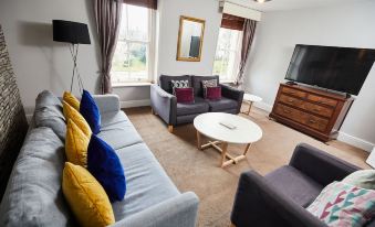 a living room with a couch , chairs , and a coffee table in front of a window at The Lawrence