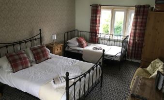 a room with two beds , one on the left side and the other on the right side of the room at The Hollies Inn