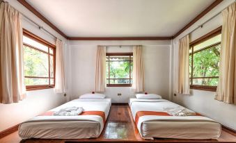 a room with three beds , one on the left , one in the middle , and one on the right at Supalai Pasak Resort Hotel and Spa