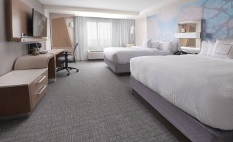 a hotel room with two beds , a desk , and a tv , all neatly arranged in a modern style at Courtyard Austin Pflugerville and Pflugerville Conference Center