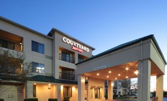 an exterior view of a courtyard by marriott hotel with a large parking lot in front of the building at Courtyard Dayton North