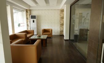 a modern living room with brown leather chairs and a white air conditioner on the wall at The Palms Hotel