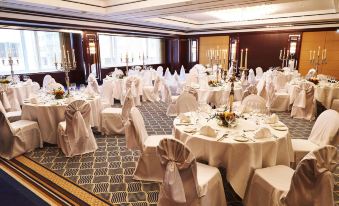 a large banquet hall with tables covered in white tablecloths and chairs arranged for a formal event at Steigenberger Graf Zeppelin