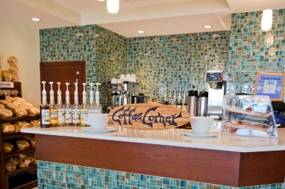 "a counter with a sign that says "" coffee lounge "" and various beverages on the counter" at Wyndham Reef Resort Grand Cayman