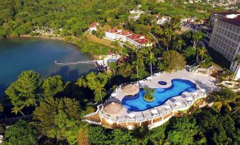 an aerial view of a resort with a large pool surrounded by trees and buildings at Bahia Principe Grand Cayacoa