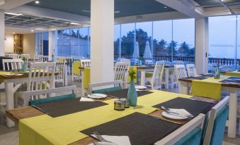 a well - decorated dining room with tables and chairs arranged for a group of people to enjoy a meal at Sunset Beach Hotel