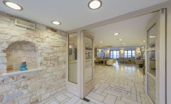 a modern interior with a stone wall , wooden furniture , and a large window , allowing natural light to fill the space at Saint George Hotel