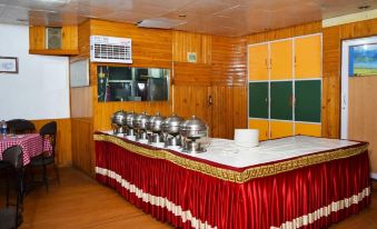 a dining room with a long table covered in a red tablecloth , surrounded by chairs at Hotel President