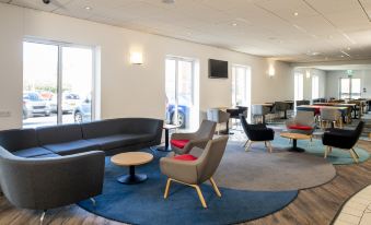 a modern lounge area with various seating options , including couches , chairs , and a coffee table at Holiday Inn Express Newcastle Gateshead