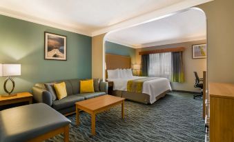 a hotel room with a king - sized bed , a couch , a television , and a dining table at Best Western Plus Executive Court Inn  Conference Center