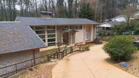 5-Bedroom 6000SF wood and glass retreat in Atlanta, surrounded by greenery.