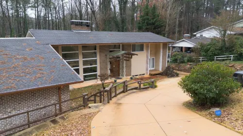 5-Bedroom 6000SF wood and glass retreat in Atlanta, surrounded by greenery.