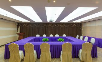 a conference room set up for a meeting , with several chairs arranged in a semicircle around a table at Open Hotel