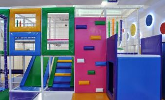 an indoor playground with various play structures , such as slides , for children to enjoy at Vanilla Rooms