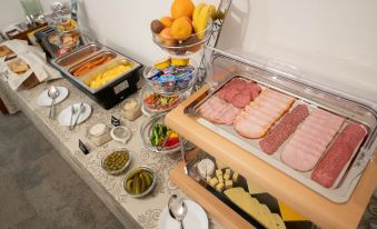 a buffet table filled with a variety of food items , including meats , cheeses , fruits , and vegetables at BlueBell Hotel
