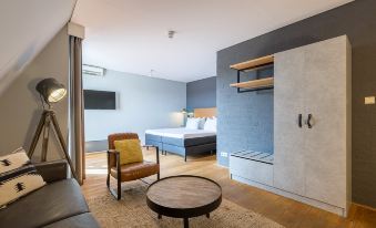 a modern bedroom with a large bed , wooden furniture , and a round table in the corner at Leonardo Hotel Lelystad City Center