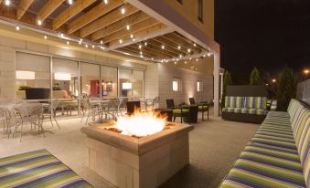 a patio with a fire pit surrounded by chairs and couches , creating a cozy atmosphere at Home2 Suites by Hilton Canton