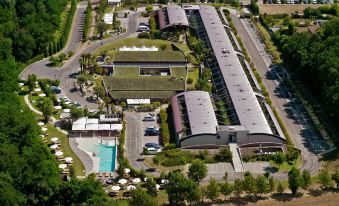 an aerial view of a large hotel complex surrounded by trees , with a pool visible in the center at Relais Bellaria Hotel & Congressi