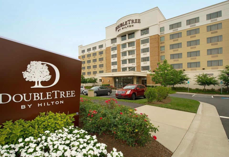 "a large hotel building with a sign that reads "" doubletree "" prominently displayed on the front of the building" at DoubleTree by Hilton Dulles Airport - Sterling