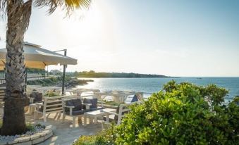 a patio overlooking the ocean , with several chairs and tables set up for outdoor dining at Apartment Sofia