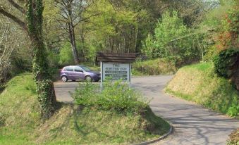 "a car is parked on a road next to a sign that reads "" offord wood park .""." at The Exeter Inn