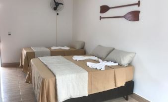 a room with two beds , one on the left and one on the right side of the room at Pousada Parapuã