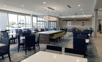 a large dining room with multiple tables and chairs arranged for a group of people at La Quinta Inn & Suites by Wyndham Tifton