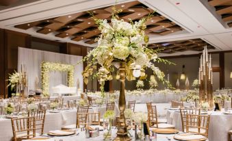 a large white and gold centerpiece with flowers is placed on a table in a room at Raleigh Marriott Crabtree Valley