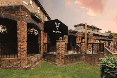 "a brick building with a sign that reads "" victoria reception "" on it , surrounded by a grassy area and trees" at Village Hotel Liverpool