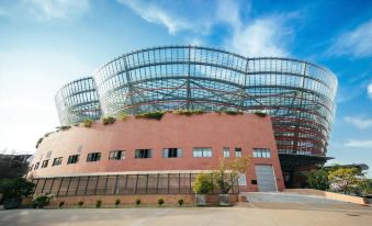 a large red brick building with a glass roof and a blue sky in the background at Capital Villa