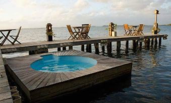 a wooden dock with a blue hot tub on it , surrounded by chairs and a table at La Ardileña
