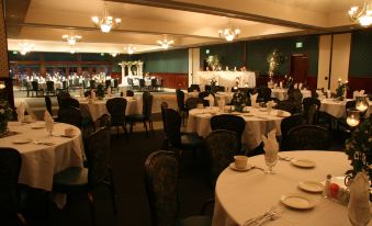 a large banquet hall with numerous dining tables and chairs arranged for a formal event at Holiday Inn Selma-Swancourt