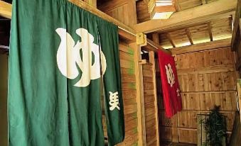 "a wooden building with two flags hanging from the ceiling , one of which has the letter "" s "" written on it" at Ganiba Onsen
