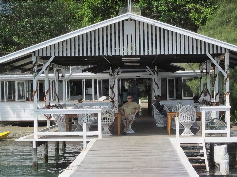 a wooden deck with a gazebo , surrounded by trees and overlooking a body of water at Driftwood Resort