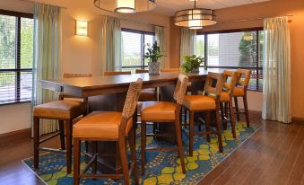 a dining area with a long wooden table and several chairs , creating a comfortable seating arrangement at Hampton Inn Portland East