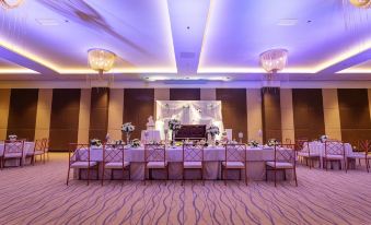 a well - decorated banquet hall with long tables , chairs , and a chandelier , ready for a formal event at Summit Hotel Tacloban