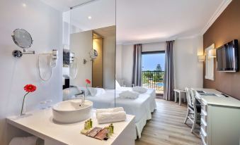 a modern hotel room with a large window , white bedding , and a view of the ocean at Barceló Isla Canela