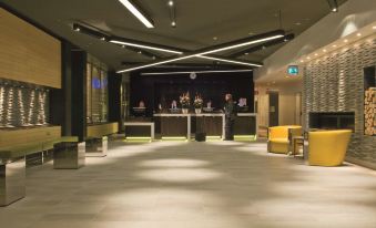 a modern hotel lobby with a check - in desk , multiple seating areas , and a seating area at Radisson Blu Waterfront Hotel, Stockholm