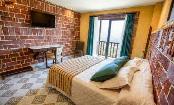 a cozy bedroom with a brick wall , a bed , and a tv mounted on the wall at Hotel Cerro La Nina
