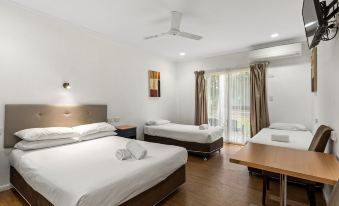 a hotel room with three beds , two of which are twin beds and one is a double bed at Discovery Parks - Rockhampton