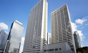 There is a large building consisting of two tall skyscrapers in the middle, with an additional tower on top at Keio Plaza Hotel Tokyo