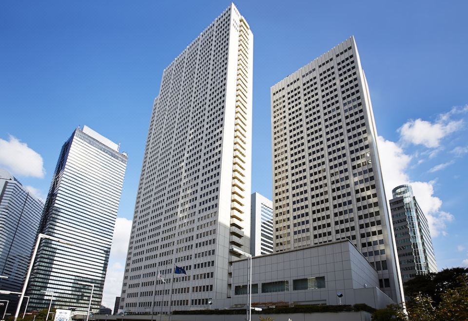 There is a large building consisting of two tall skyscrapers in the middle, with an additional tower on top at Keio Plaza Hotel Tokyo
