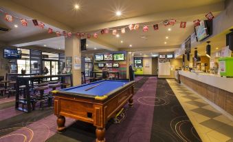 a well - lit indoor area with a pool table , arcade games , and multiple tvs , creating an inviting atmosphere for patrons at Nightcap at Glengala Hotel