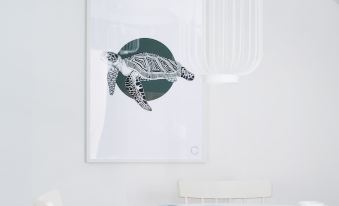 a white room with a table , chairs , and a framed poster of a turtle on the wall at Colors Apartments