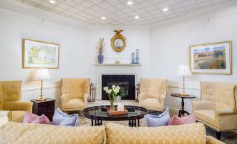 a well - decorated living room with a fireplace , two couches , and two chairs arranged around the room at The Farmington Inn and Suites