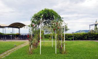 a white archway with a flower arch is in the middle of a grassy field at La Castellana
