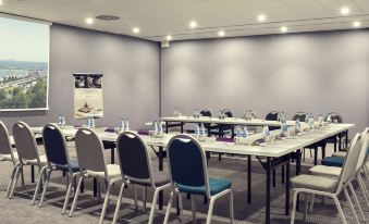 a conference room with multiple rows of tables and chairs arranged in a semicircle , creating an intimate setting for meetings at Hotel Mercure Gdynia Centrum