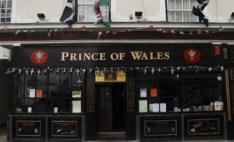 "a small town with a pub named "" prince of wales "" on the side of the building" at Prince of Wales
